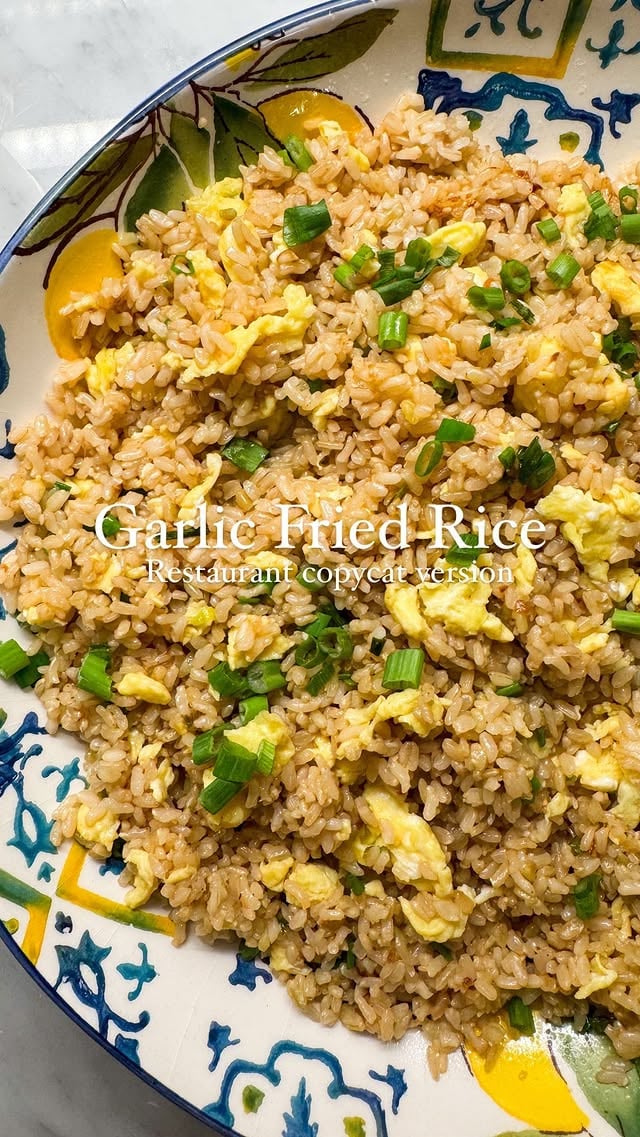 Garlic Fried Rice 3 beaten eggsNeutral Oil for frying5 tbsp of salted butter6 cloves of chopped garlic 4 chopped spring onions whites separate to the green 1 tsp or more of sesame seeds 1 tsp of sesame oil 2 cups of any rice. I used the Trader Joe’s brown rice it’s my favorite. But basmati also works great. Ideally should be short grain Seasonings: 1/2 tsp of salt, 1/2 tsp of white sugar, 1 tsp of chicken powder I use the @shaheenroastery brand 2 tbsp of soy sauce In a frying pan over medium heat scramble the eggs. Remove from pan. Return the pan back to the heat and place the heat on high. Add 2 tablespoons of butter and a little bit of oil. When the butter gets warmed up add the garlic and the whites of the green onions. Once the garlic gets fragrant and Golden add in the sesame seeds and the rice and 2 more tbsp of butter. Once the butter melts add in the seasonings as well as the soy sauce. Mix well, adjust seasoning. Pour the sesame oil and Add another tbsp of butter right before serving. Top with green spring onions and serve immediately. Come back tomorrow for the Fish Teppenyaki recipe that goes great with this rice. #asiancooking #copycat #friedrice by @mariumhosein